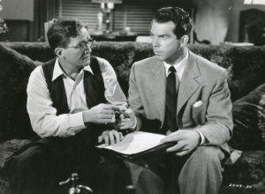 Mr. Dietrichson (Tom Powers) signs his own death warrant, prepared by Walter Neff (Fred MacMurray).